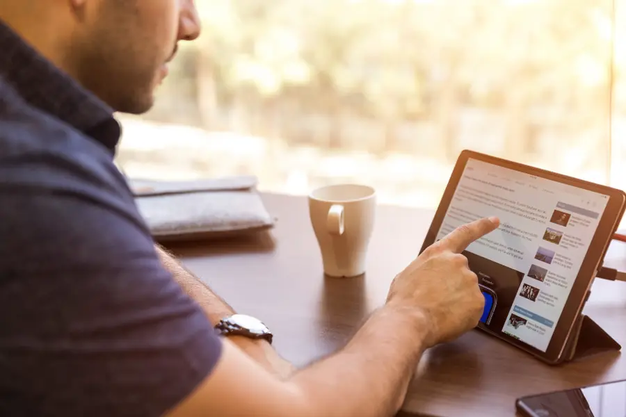 Man reading at a desk with a coffee in warm morning light, the routine VapoCept is designed to fit into
